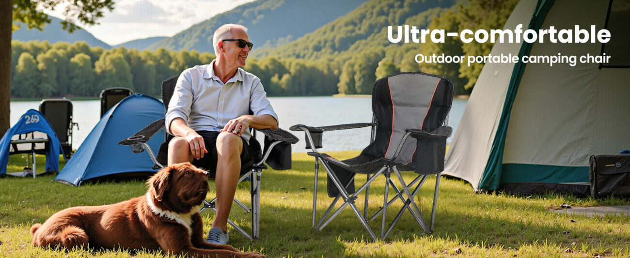 An elderly person and a pet dog camping by the lake, with two extra-wide breathable camping chairs placed on the lawn, against the backdrop of the lake tents, conveying a comfortable outdoor experience of companionship