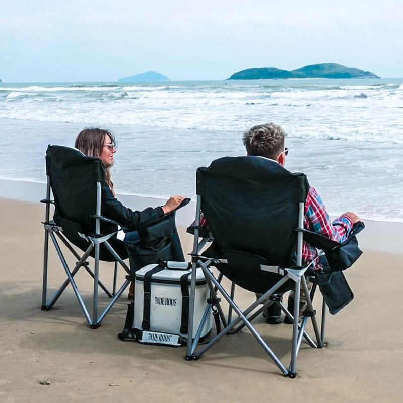 Black high back folding camping chair beach use scenario picture; outdoor portable leisure chair suitable for camping picnic fishing.