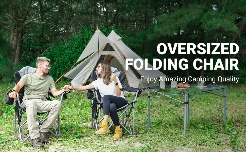 Oversized Folding Camping Chair: Couple relaxing at a forest campsite with a tent and outdoor table, portable heavy-duty seating for camping, picnic, and fishing